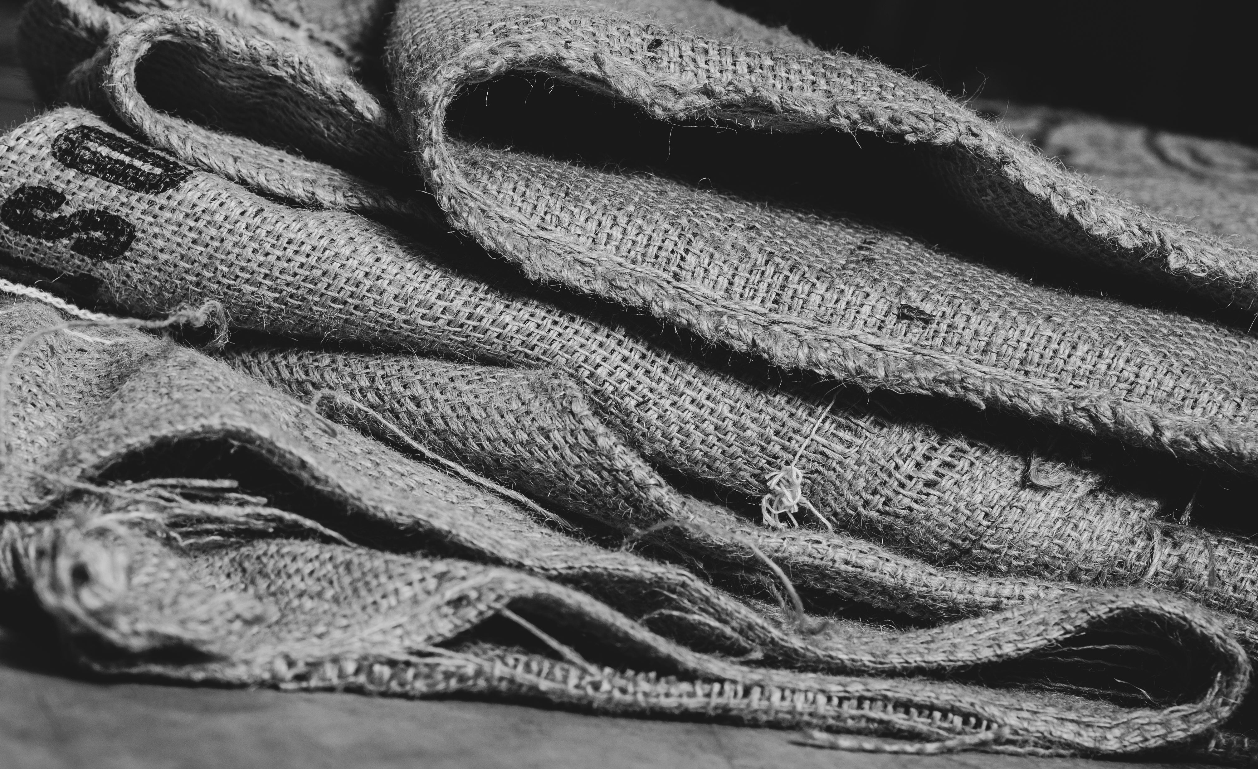 Stacked burlap coffee sacks showing woven texture and worn seams